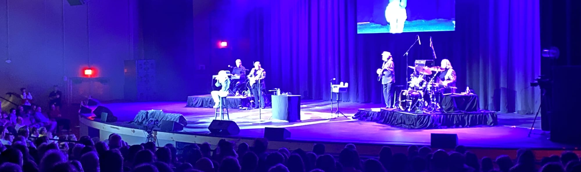 signer on stage in chair washed out by the lights Davenport